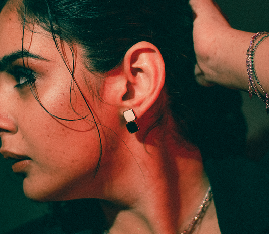 Close-up of a woman wearing a chess style earrings studs