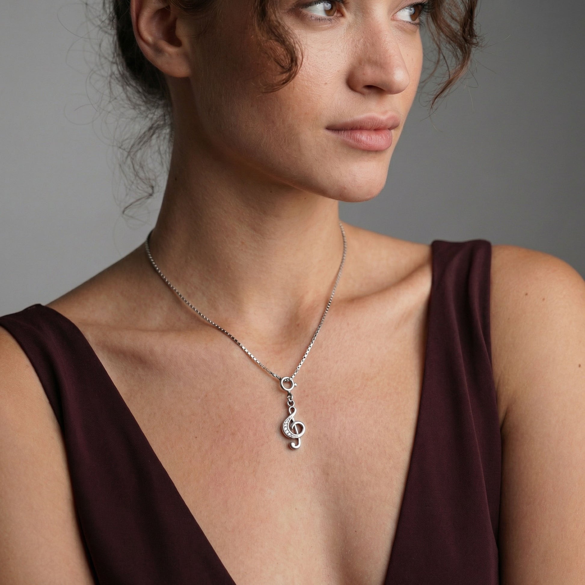 Silver Clef Charm worn as a pendant on a chain