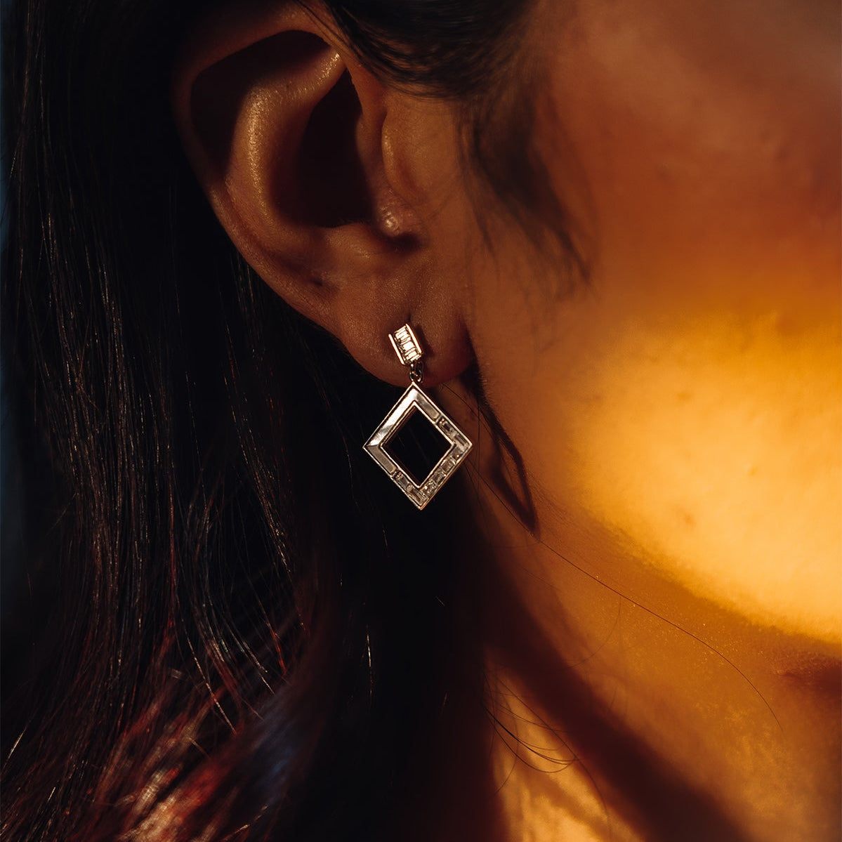 Sterling silver dangling square earrings with mother of pearl on model