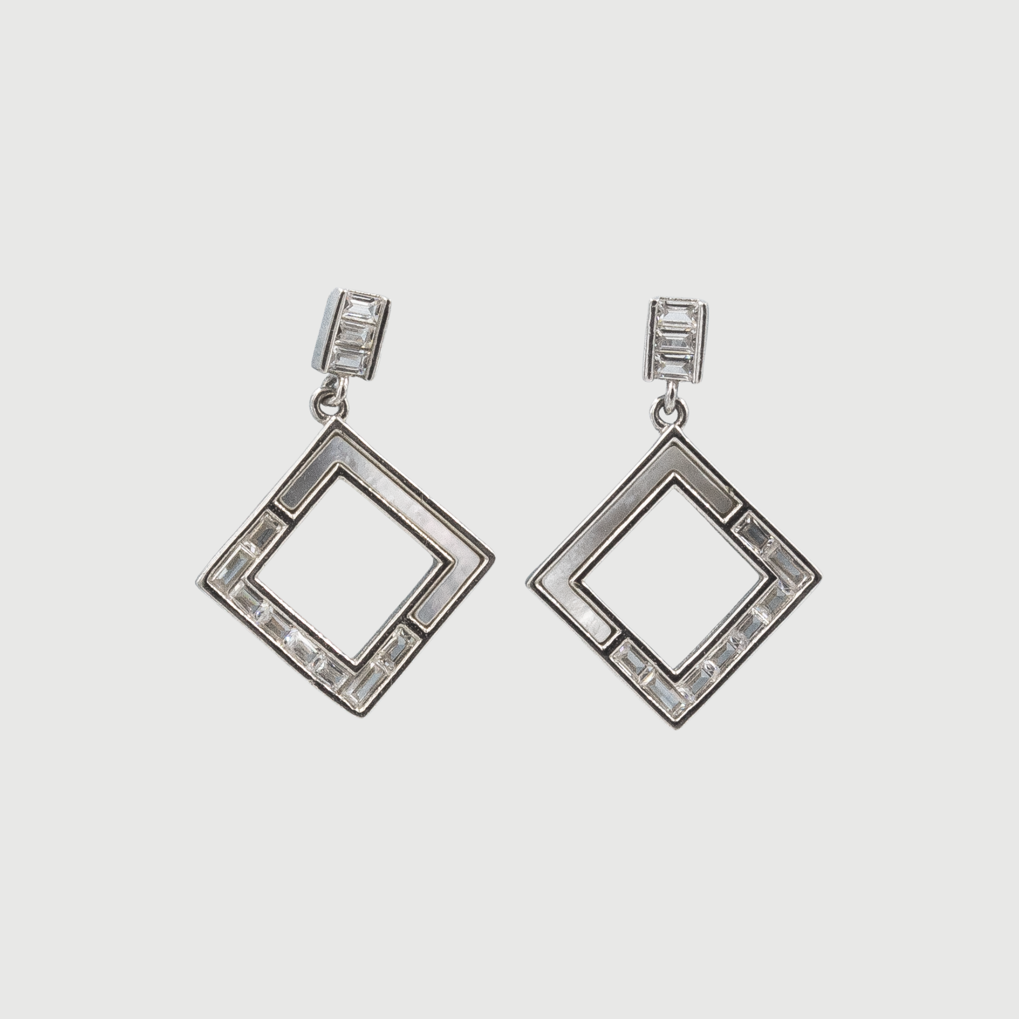 A pair of square-shaped earrings with one half featuring mother-of-pearl and the other half with sparkling cubic zircon stones, all set in silver.