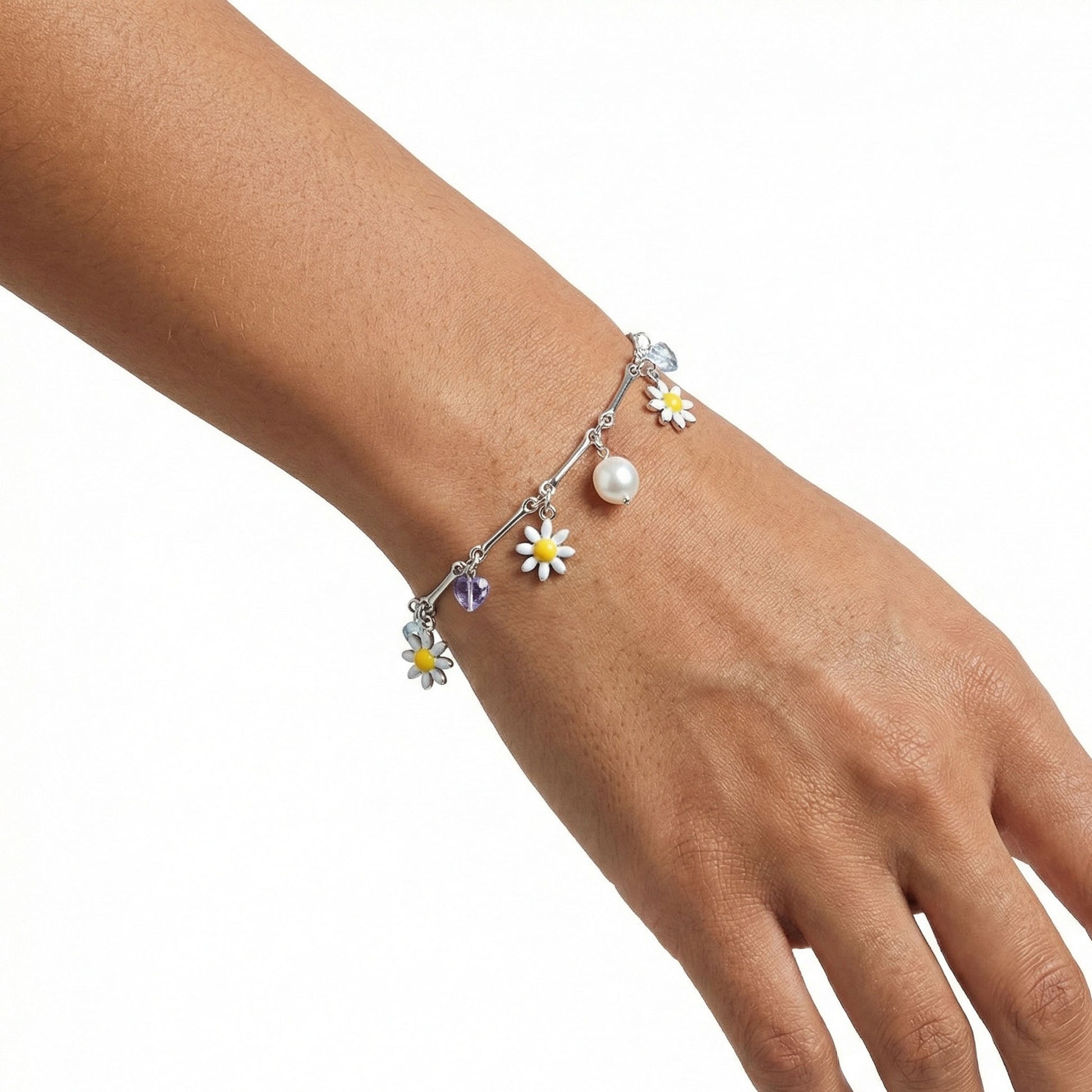 Silver bracelet for her, 925 silver bracelet, Charm bracelet on a lady hand it has few stones in white, purple color as well as a pearl in middle with white daisies as charm