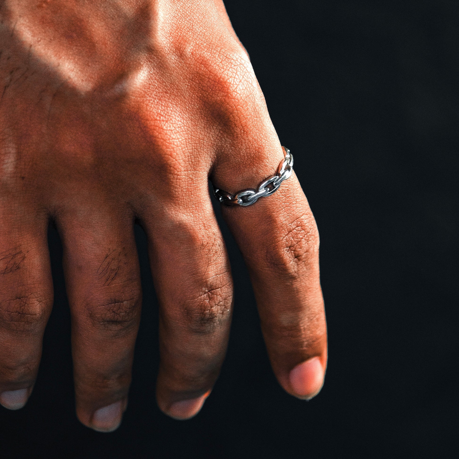Hand wearing a silver chain ring