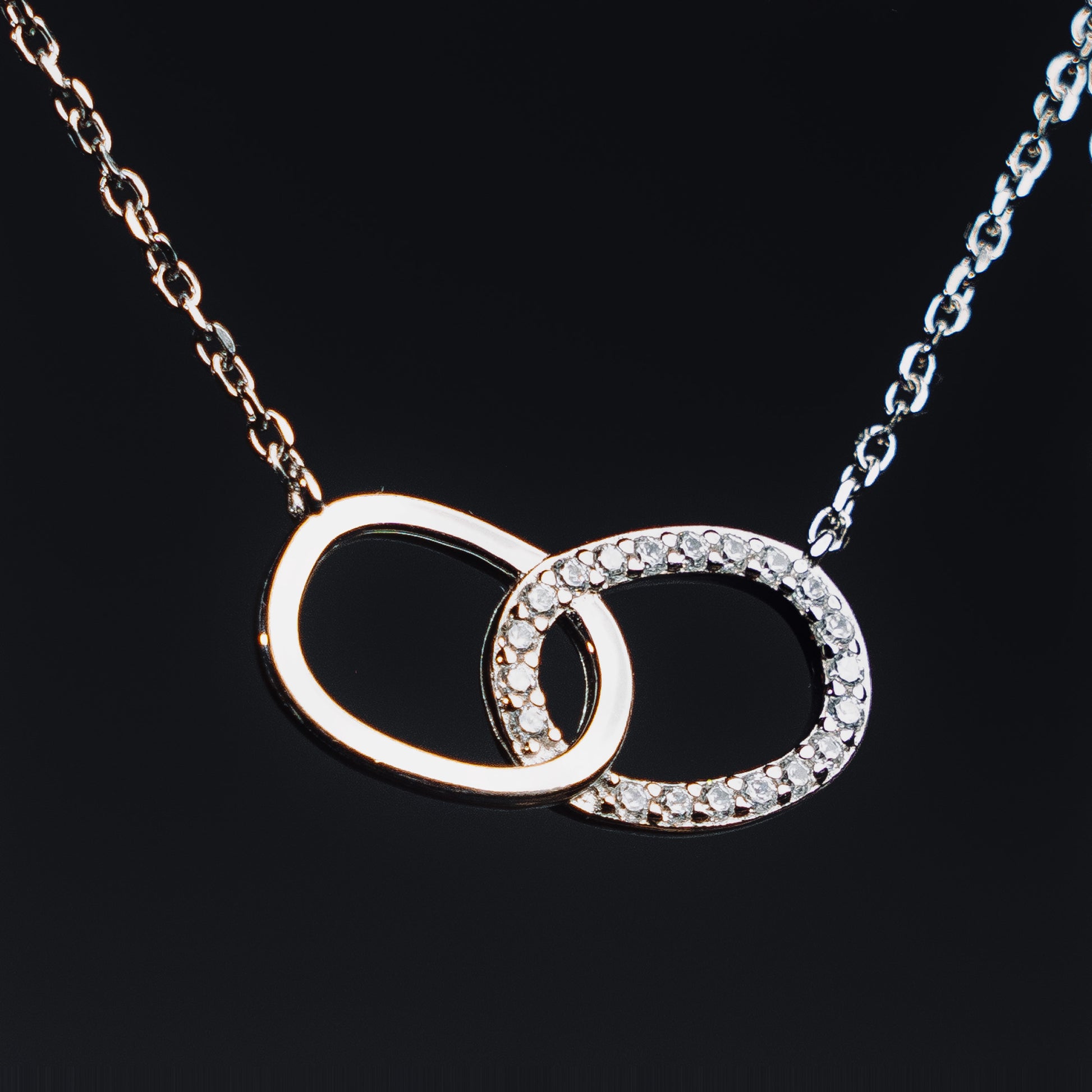 Website Alt Text
Elfy 925 Sterling Silver Infinite Connection Pendant Necklace featuring two interlocking oval linksone polished silver and one encrusted with shimmering Zircon stones