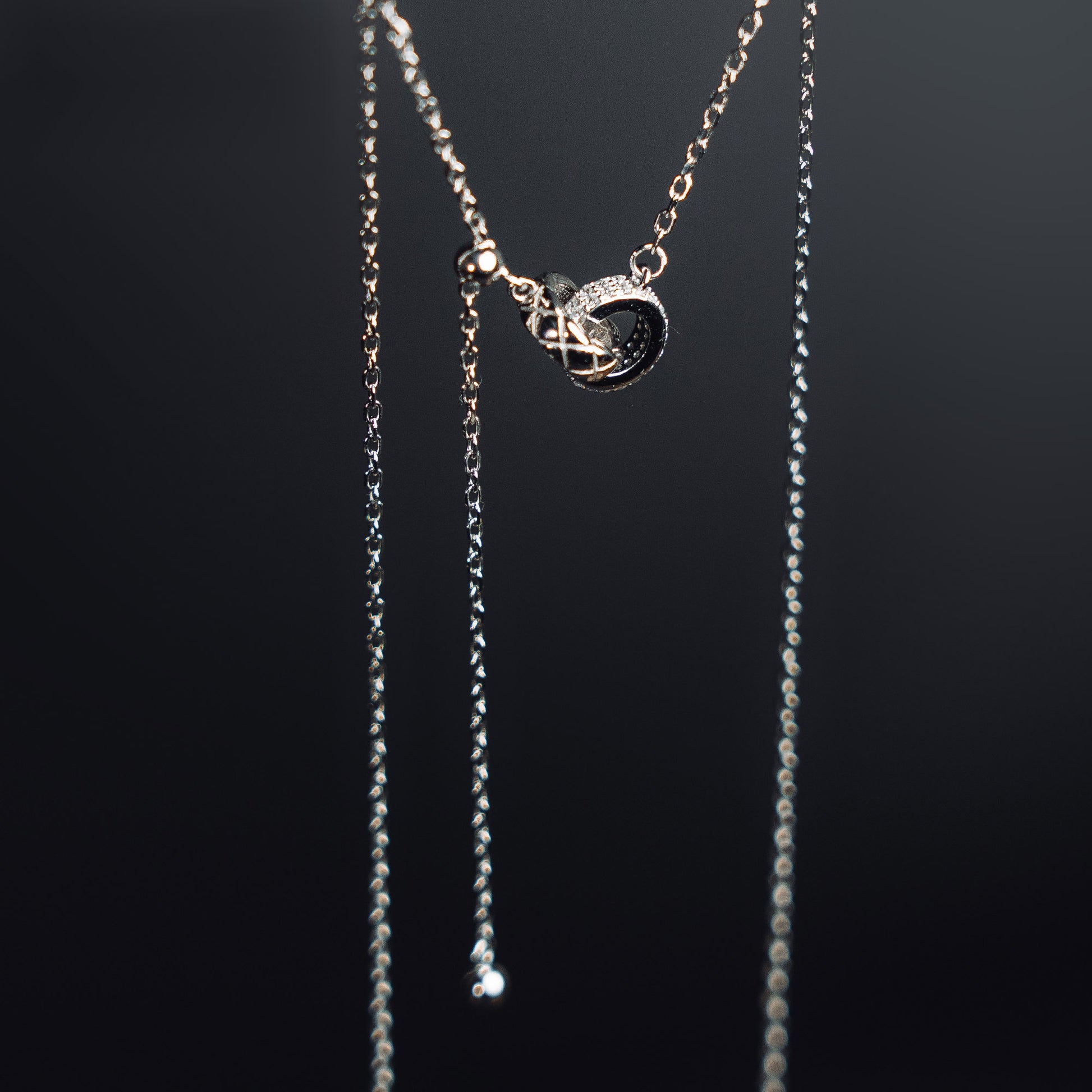 Necklace with a black pendant on a dark background