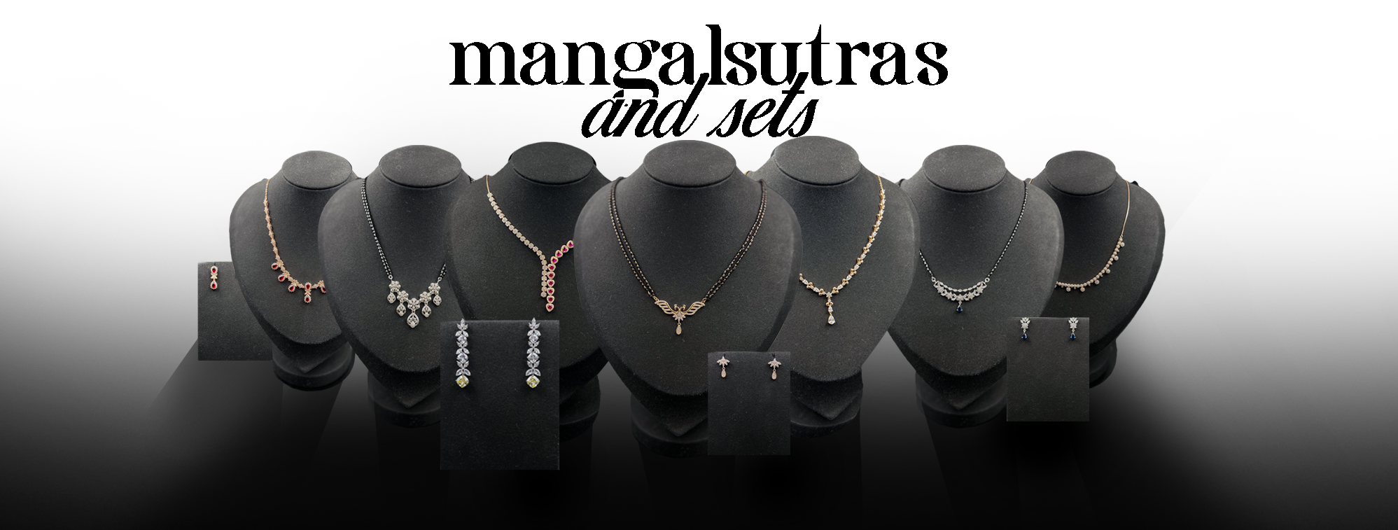 Jewelry display with mangalsutras and sets on black mannequins against a gradient background.