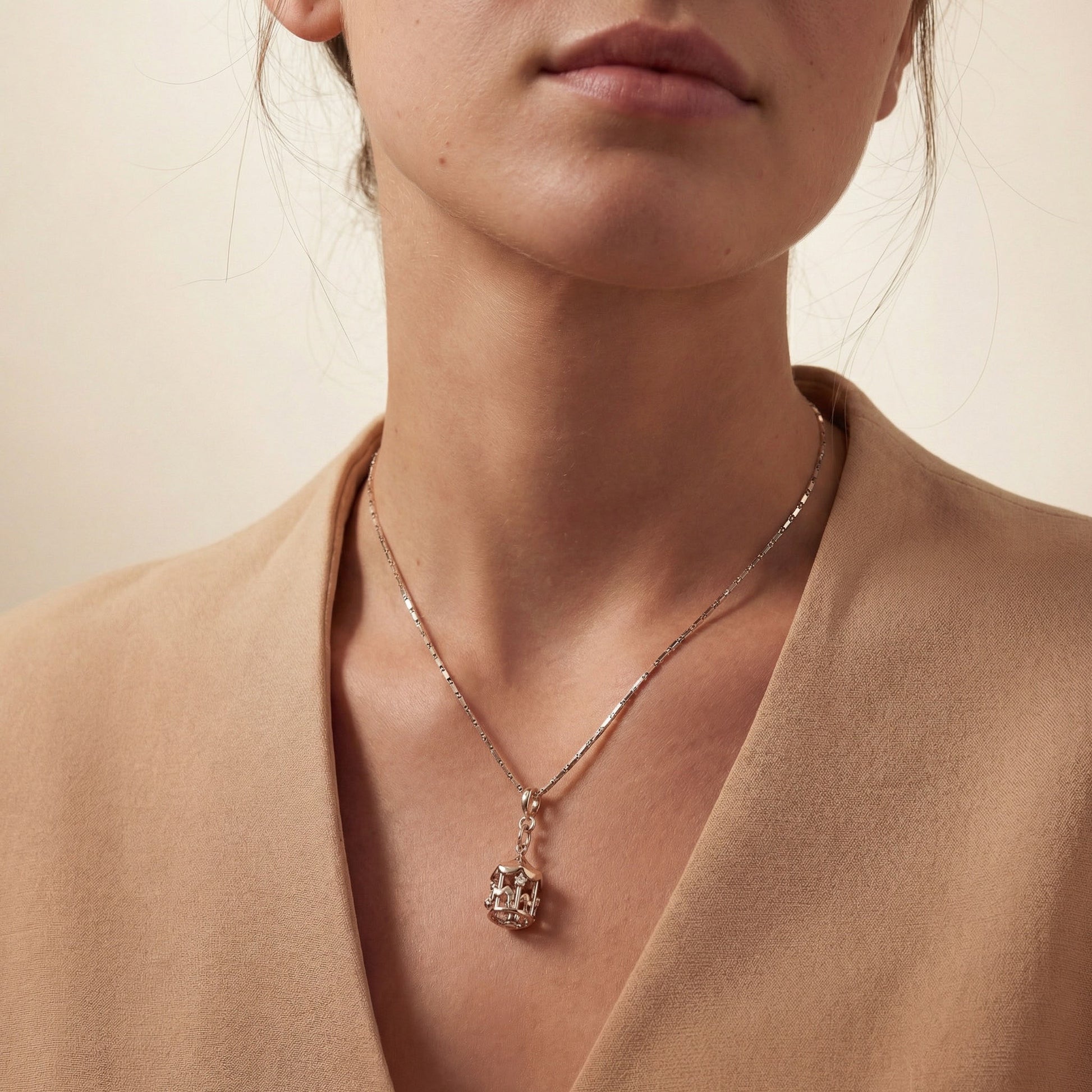 Close-up of a person wearing a delicate chain with merry go round charm. Its a silver nexus chain and silver merry go round charm. Merry go round charm, silver charms, sterling silver charms, charm bracelet, charm chain