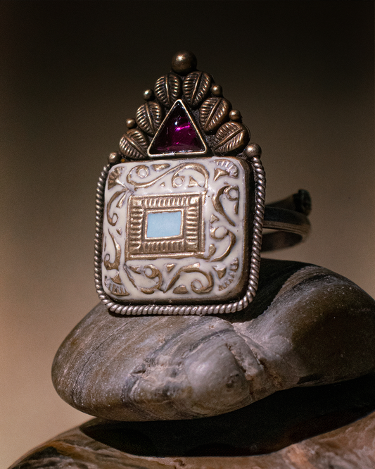 Traditional ring with intricate design and gemstone on a stone surface