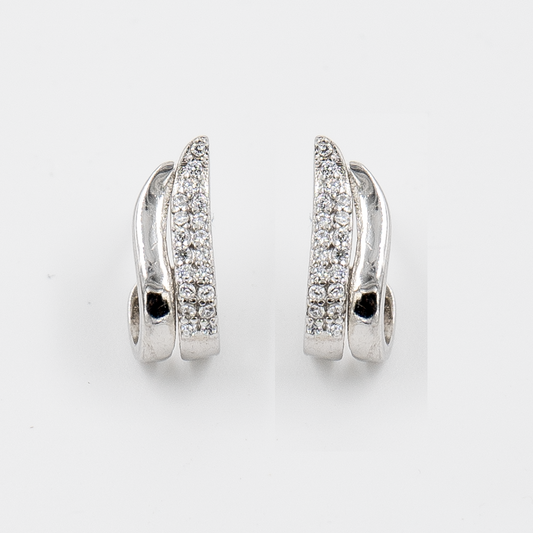 A pair of silver stud earrings featuring a wave shape with one line adorned with cubic zirconia and another line plain.
