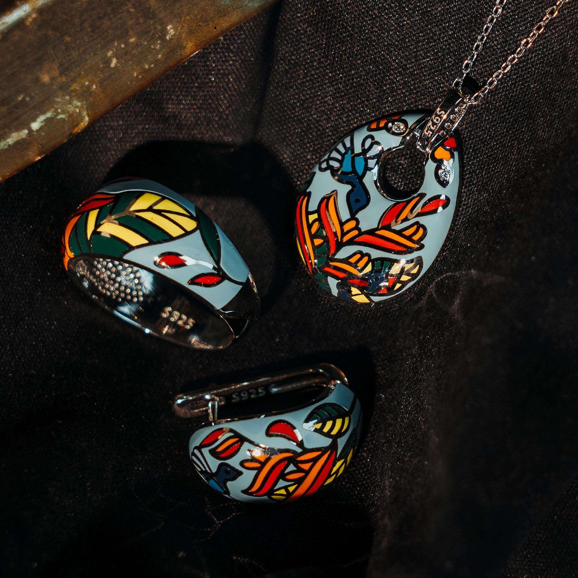 A sterling silver pendant plus earrings plus ring set of enamel of green color with print of birds and leaves.