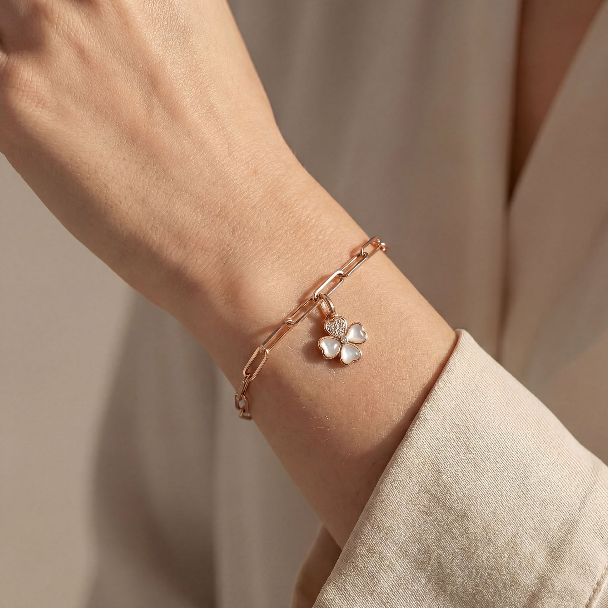 Rose gold bracelet with a clover charm, goodluck charm on a wrist