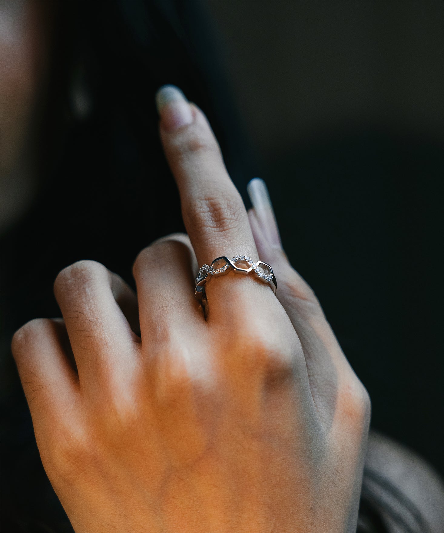 Sterling silver honeycomb halo ring worn on a finger