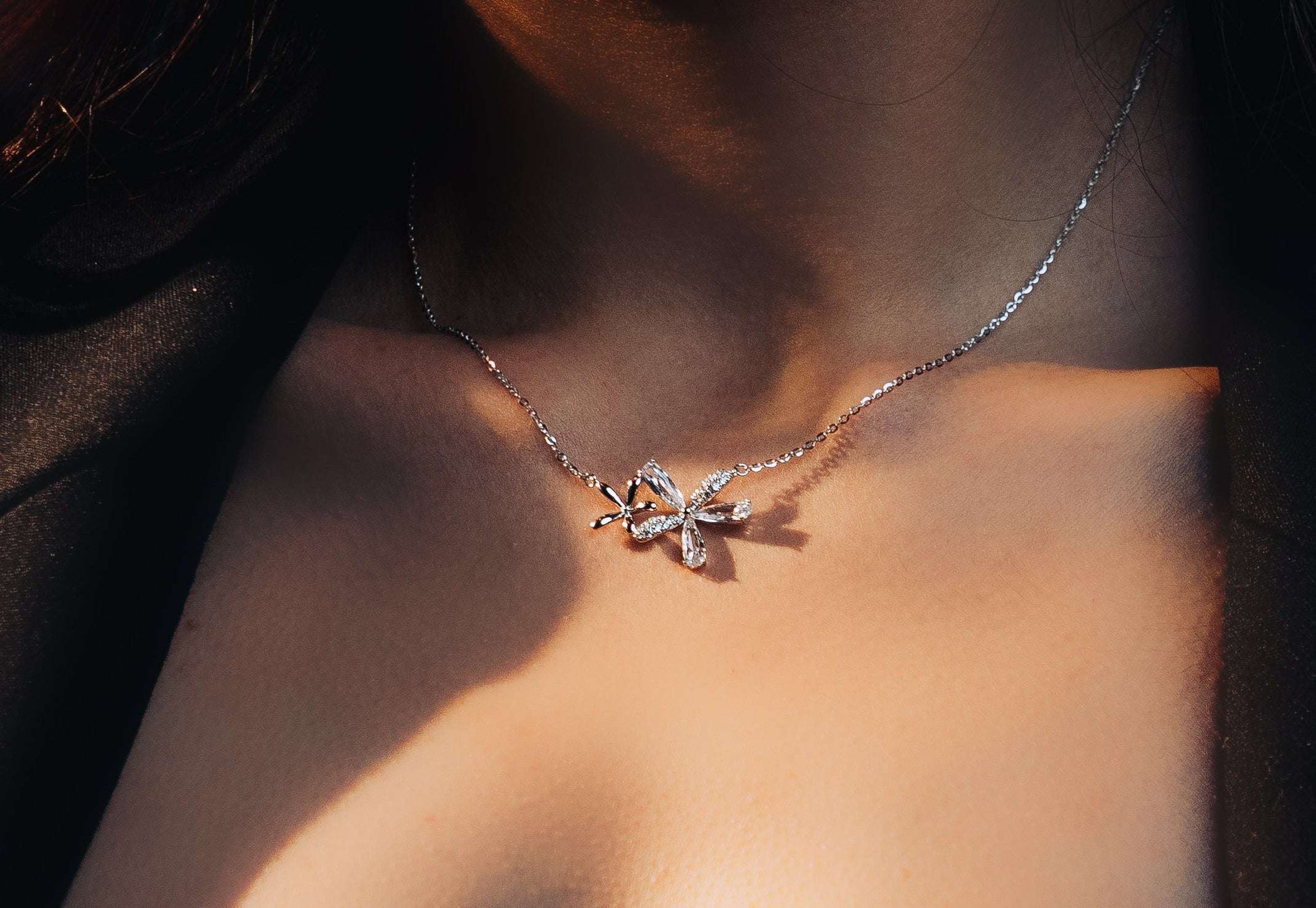 Sterling silver two flower pendant on a model.