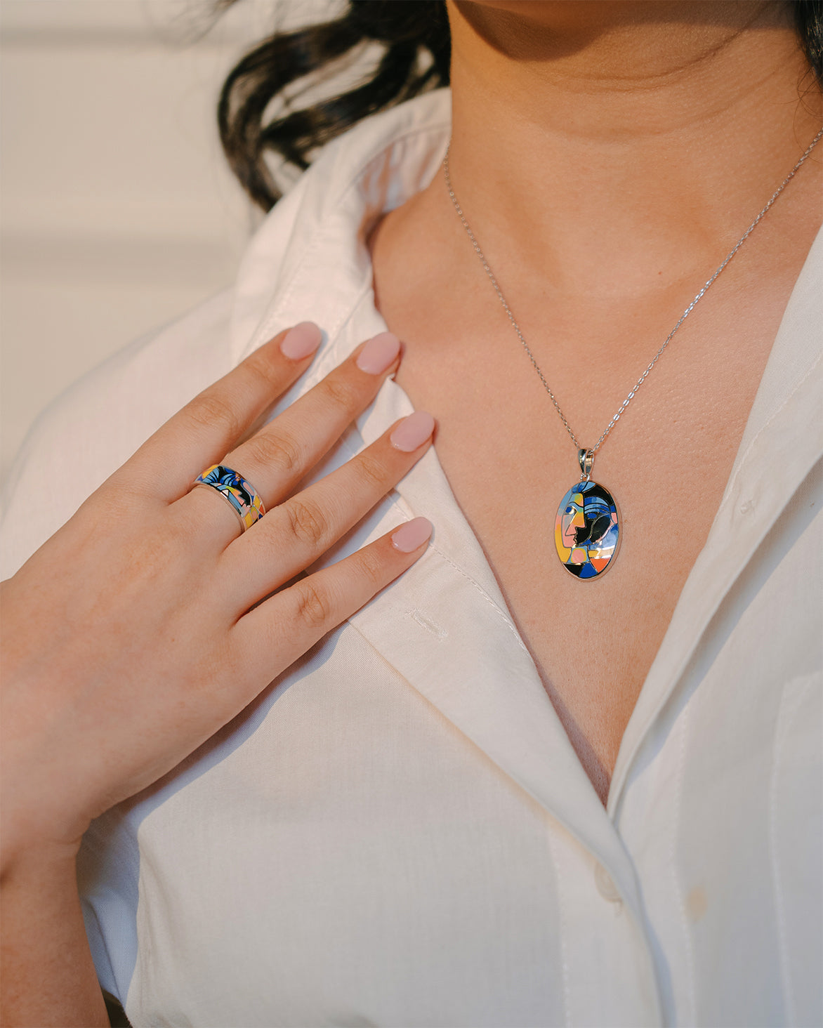 A sterling silver enamel set with pendant earrings and ring set with print of a modern muse