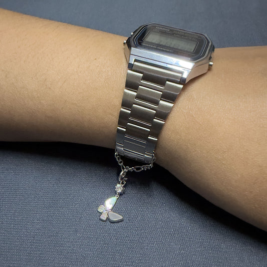 Minimalist silver watch charm chain with detachable charm hanging from wristwatch strap