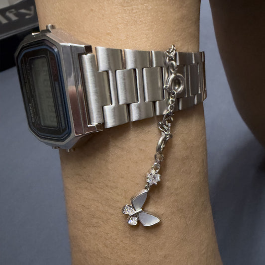 Minimalist silver watch charm chain with detachable charm hanging from wristwatch strap