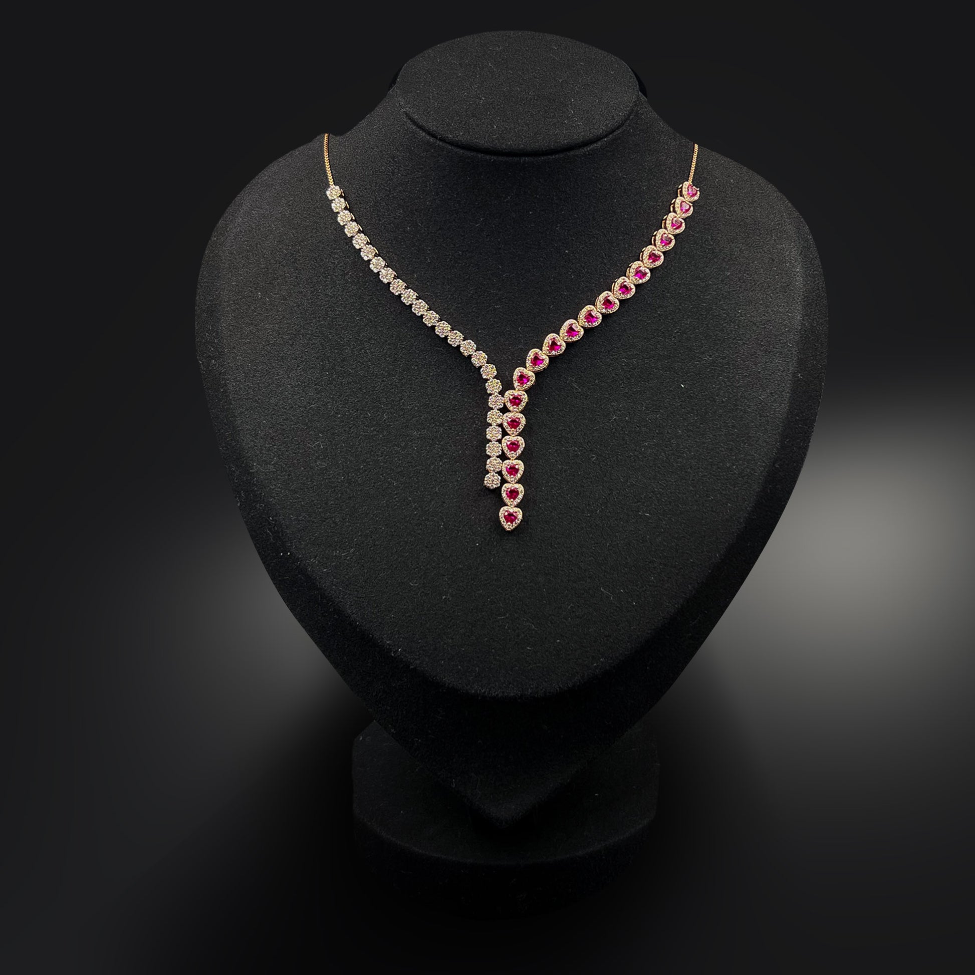 Necklace with red and clear stones on a black stand